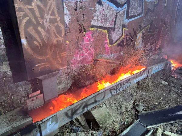 A blazing fire by a train track in Brockley.