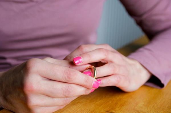 Woman fiddling with a wedding ring and debating taking it off